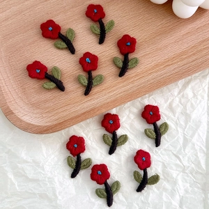 Detailed macro view of handmade floral embroidery patches in classic red and green colors