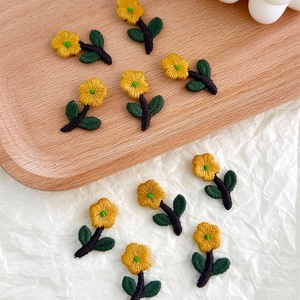 Detail of yellow flower embroidery patches with green leaves for DIY clothing accessories