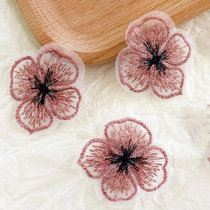 Gros plan de patchs fleurs de trèfle rose brodés pour la décoration de vêtements DIY