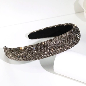 Gros plan du serre-tête large avec strass gris foncé sur un support blanc élégant