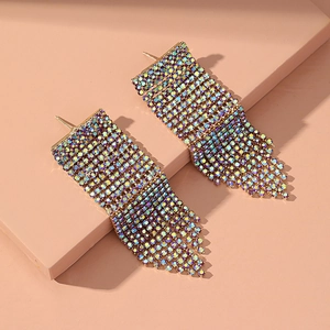Macro detail of long golden tassel earrings with sparkling iridescent AB rhinestones