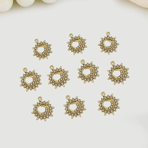 Macro detail of 10 gold alloy sun charms with sparkling crystals for DIY jewelry making