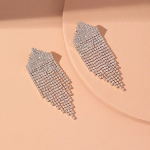 Close-up of luxury gold-plated tassel earrings with layered shimmering crystal fringe