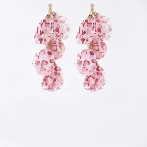 Boucles d'oreilles bohèmes à pompons en tissu cœur rose avec détails dorés