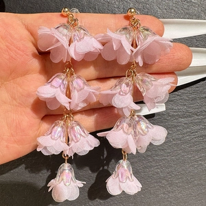 Pink floral tassel earrings with multilayered fabric petals and iridescent accents