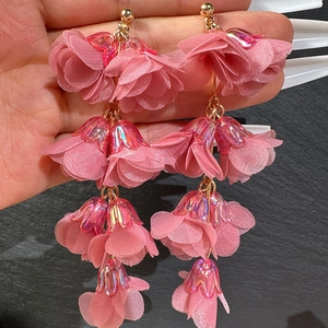 Detailed view of pink chiffon flower tassel earrings with iridescent crystal accents