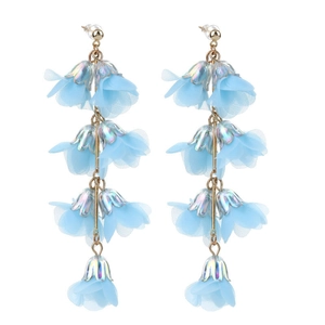 Detail of light blue tulle flower earrings with iridescent metal finish and long tassels
