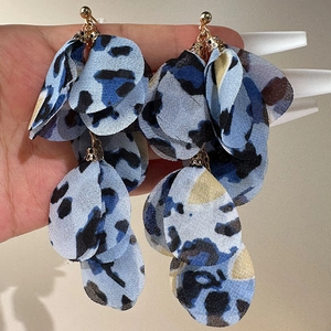 Handmade leopard print fabric petal tassel earrings with gold sphere stud on a neutral background