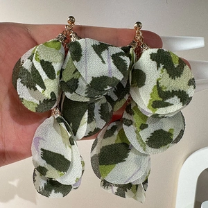 Macro shot of oversized handmade fabric petal earrings in green camo print on metal stud