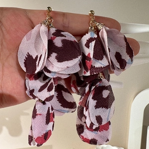 Detail of layered fabric petal drop earrings featuring colorful leopard animal prints
