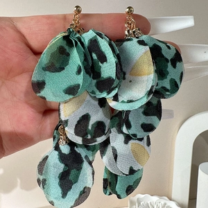 Close-up of leopard print fabric petal drop earrings with gold metal and rhinestone detail