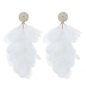 Détail de boucles d'oreilles à pompons en pétales d'organza blanc avec perles et strass