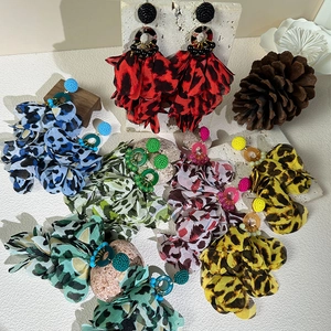 Bohemian leopard floral tassel earrings with beads on marble surface with nature props