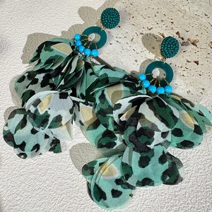 Detail of leopard print fabric flower earrings with green beads and tiered chiffon petals
