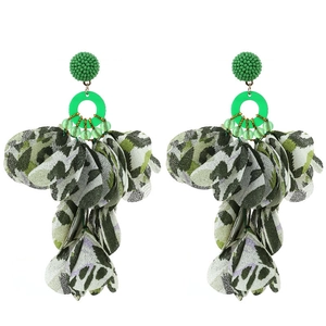 Macro detail of handmade fabric floral earrings with leopard print petals and green beads