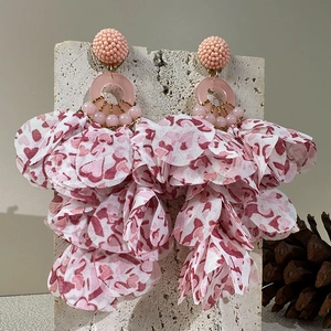 Detailed macro shot of pink fabric flower tassels on long bohemian statement earrings