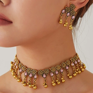 Ethnic vintage gold jewelry set with pink teardrop gems and boho floral patterns