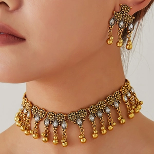 Vintage gold jewelry set with floral relief and white teardrop charms on a female model