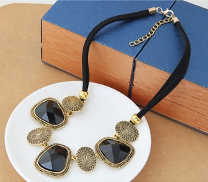Détail du collier bohème avec cristaux noirs et disques métalliques dorés vintage
