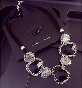 Détail du collier bohème avec pierres noires géométriques et montures en métal argenté