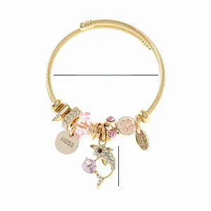 Détail du bracelet ajustable en or avec pendentif dauphin strass et perles cristal
