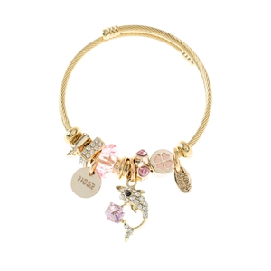 Bracelet câble doré avec pendentif dauphin et perles en cristal rose sur fond blanc