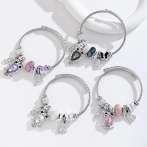 Detail of adjustable wire bracelets with owl and heart charms in multiple colors