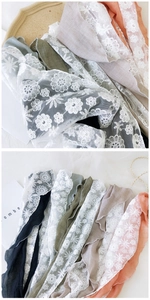 Close-up of cotton linen scarves with delicate floral lace borders in multiple soft colors