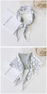 Detail of grey cotton scarf with intricate white floral lace trim and patchwork design