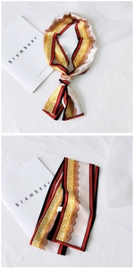 Detail of silk skinny scarf featuring yellow leopard print and lace edges in red and black