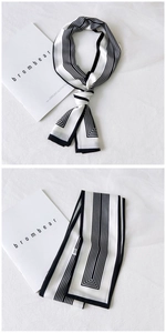 Detailed view of long black and white striped silk scarf with elegant knotted styling