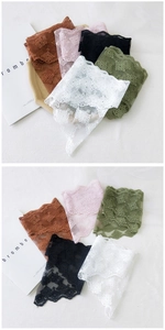 Detail view of five assorted colors of hollow floral lace scarves with crochet edges