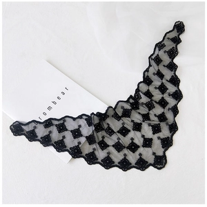 Close-up of black lace triangle scarf with floral embroidery and hollow mesh texture