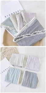 Detail of four-color plaid cotton linen bandanas with decorative white pom pom lace trim