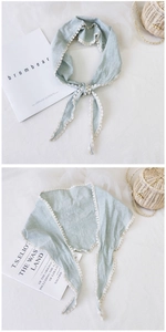 Detail of mint green gingham cotton scarf with delicate white lace trim on fabric background