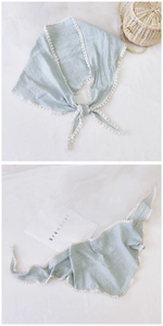 Detail of light green plaid cotton linen triangle scarf with white lace pompom trim edge