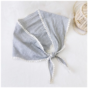 Detail of blue gingham cotton linen neckerchief with white lace trim and knot design