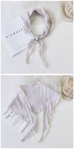 Macro detail of plaid cotton linen neck scarf featuring delicate white lace trim and knot