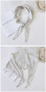 Detail of plaid cotton linen neckerchief with white lace pom-pom trim and soft fabric texture