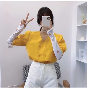 Detail of yellow short-sleeved shirt paired with white strawberry print cooling arm sleeves