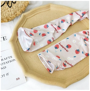 Close-up of pink sun protection arm sleeves with cute strawberry and daisy patterns