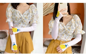 Detail of white ice silk sun sleeves with yellow pineapple print and finger hole design