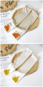 Detail of fruit print cooling sun protection sleeves in beige and off-white silk fabric