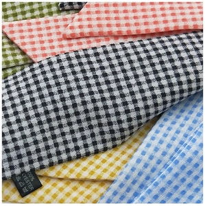 Gros plan de la texture à carreaux et des étiquettes en polyester sur les foulards minces