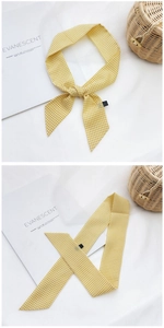 Détail d'un foulard en polyester à carreaux jaunes montrant la texture et le style
