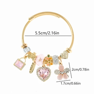 Détail du bracelet doré ajustable avec breloques cœur et fleur et diamètre de 5,5 cm