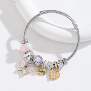 Steel beaded bracelet with pink butterfly and love heart charms on white background