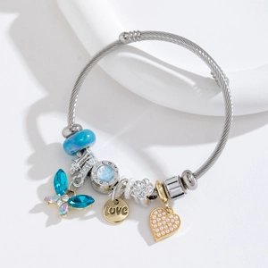Stainless steel beaded bracelet with blue butterfly charm and heart pendant on white background