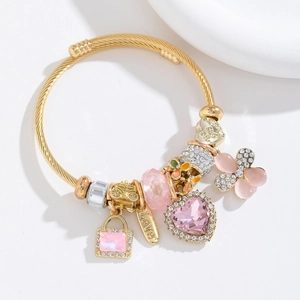 Bracelet doré torsadé avec pendentifs en cristal rose et breloques cœur