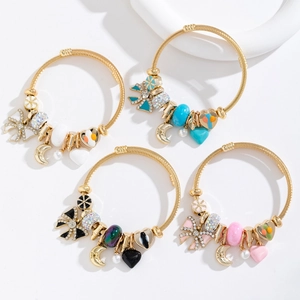 Détail de quatre bracelets dorés avec perles de cristal et pendentifs en forme de cœur